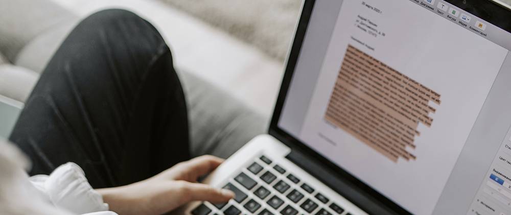 Woman sitting at a laptop working on a paper