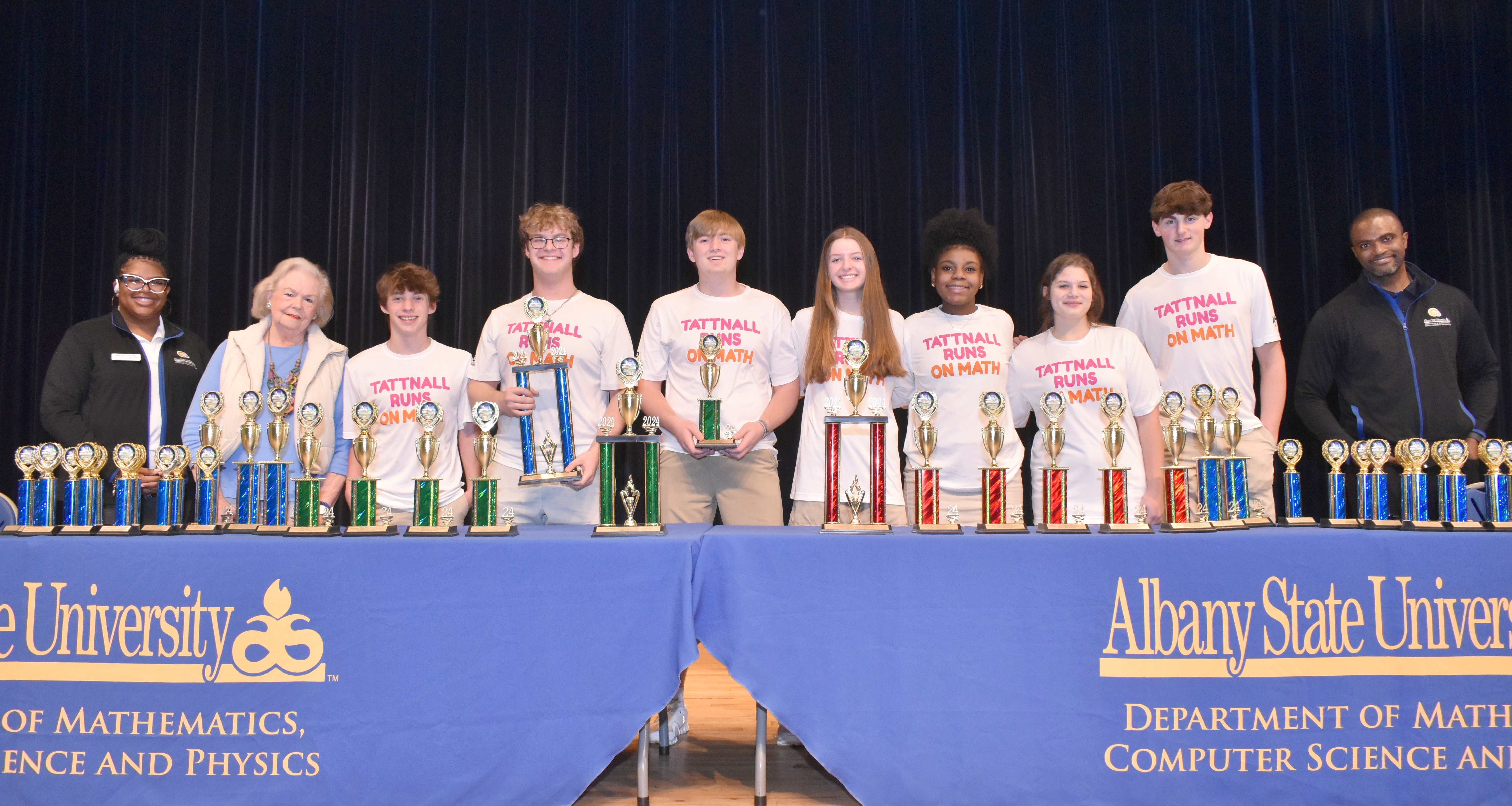 students standing with trophies 