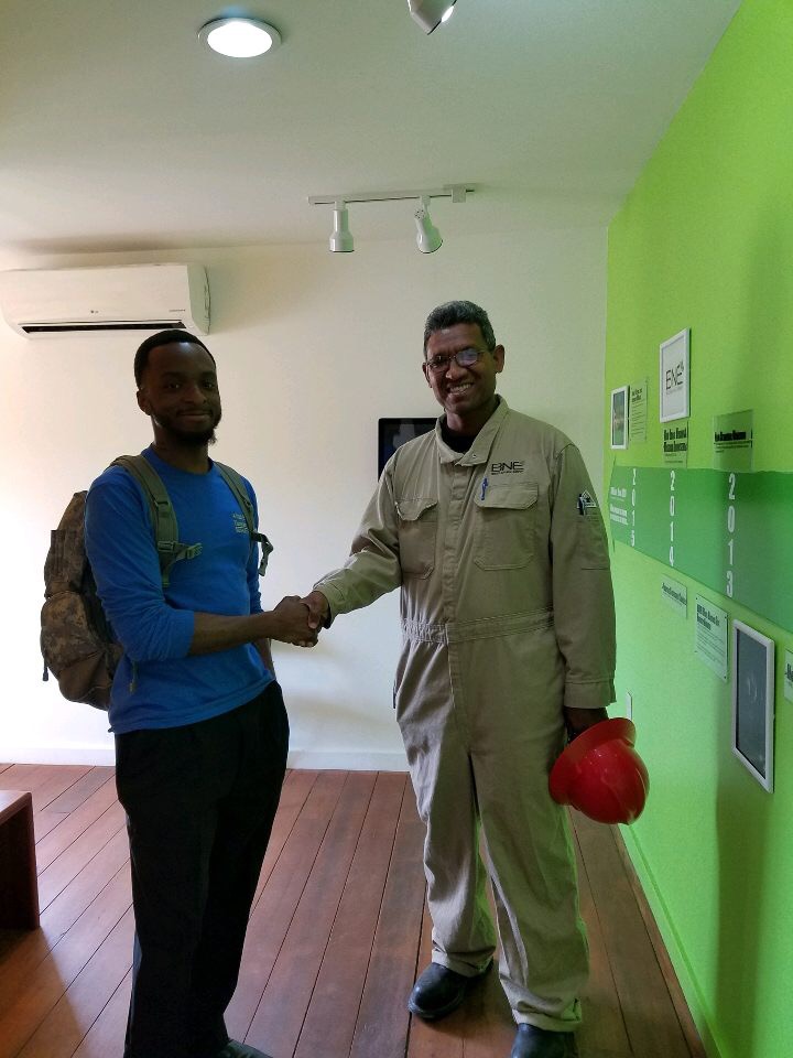 student shaking hands with energy plant worker.